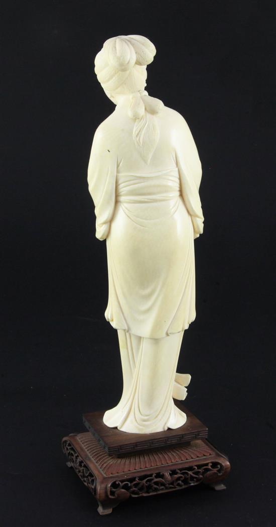 A Chinese ivory figure of a lady holding a flowering peony branch, early 20th century, total height 30cm